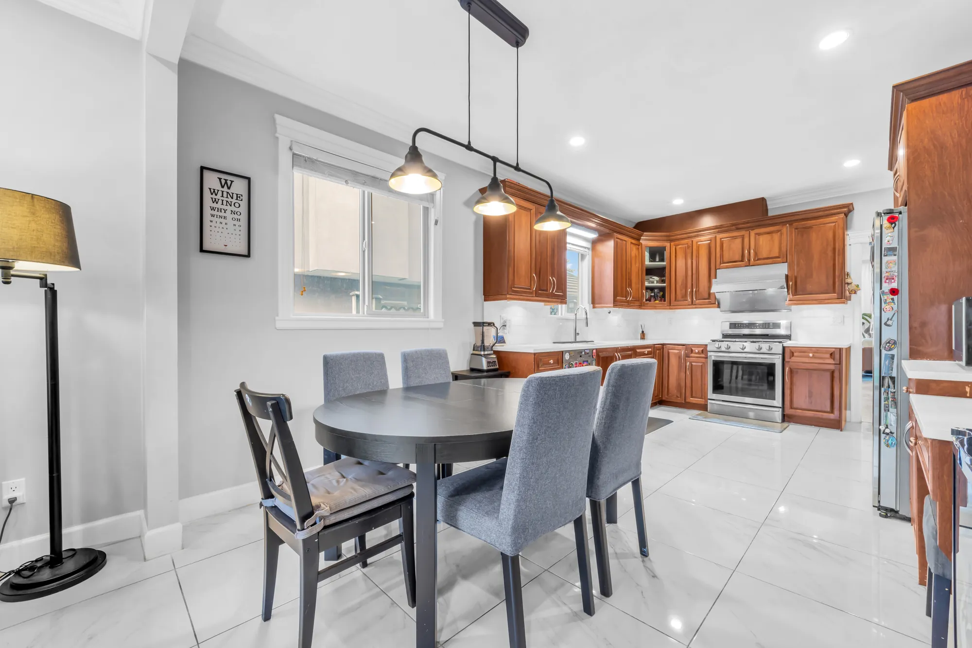 The breakfast table toward the kitchen: the stainless range and the wood cabinets