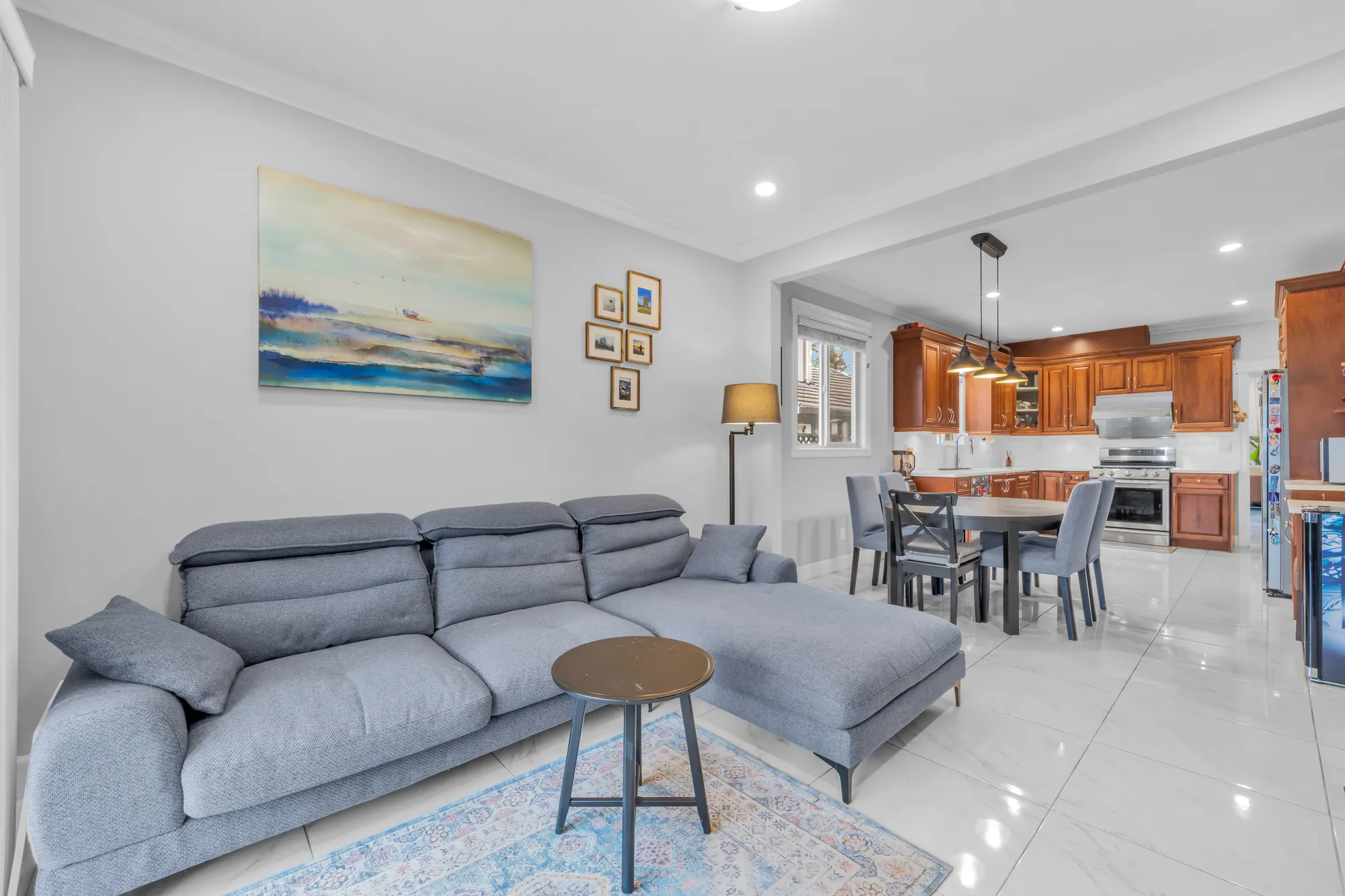 The family room toward the kitchen: the sectional sofa, the breakfast table, the wood cabinets beyond
