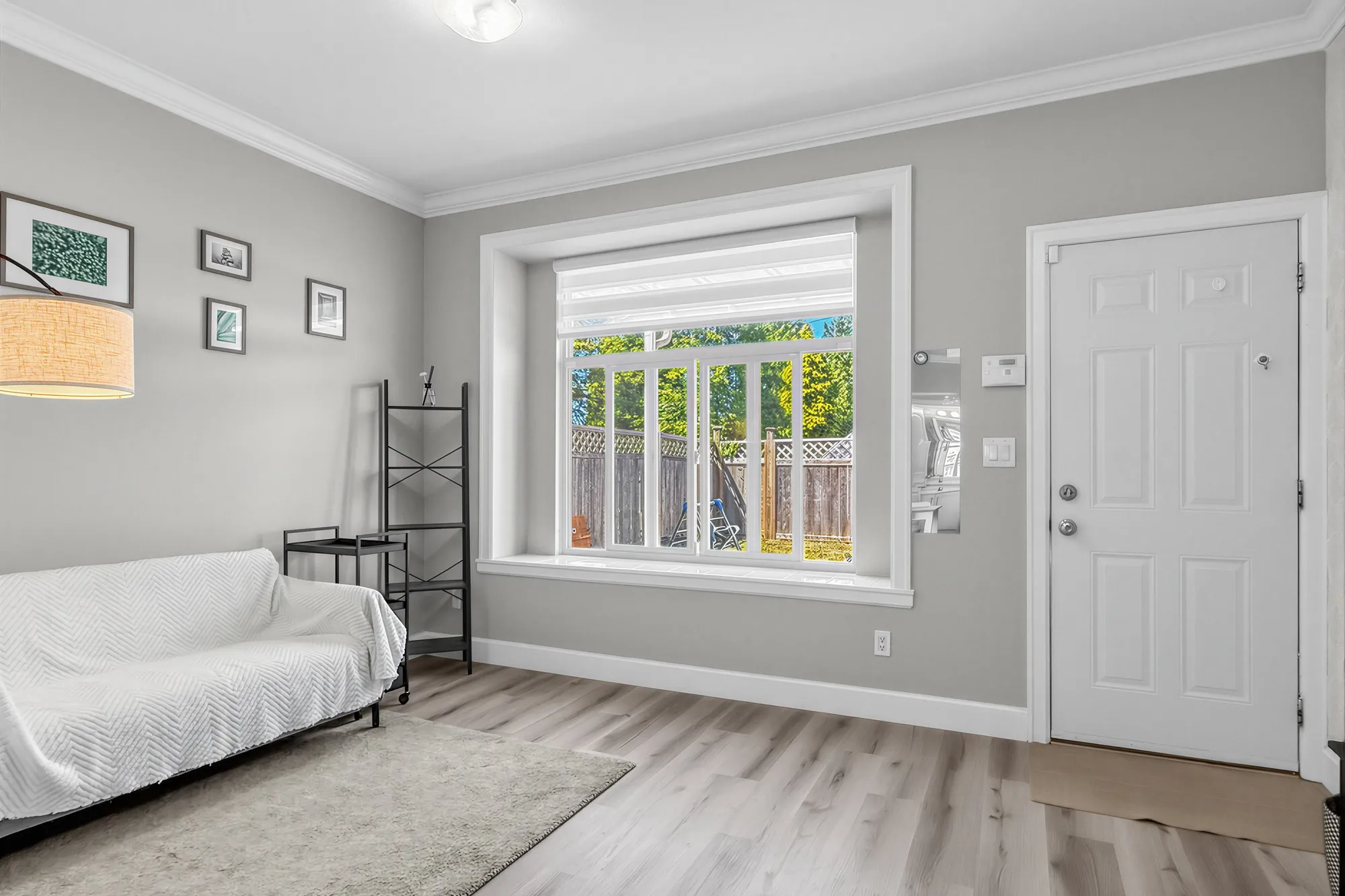 The guest suite's living area toward its door: the loveseat, a floor lamp and shelves, the window